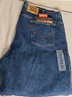 Folded jeans showing leather patch, pocket, hangtags, size sticker