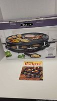 Box showing Bella raclette grill and included cookbook
