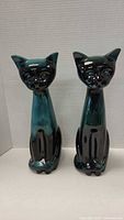 Front view of both drip-glazed ceramic cats