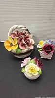 Three bone china floral figurines grouped