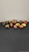 Group shot of all eleven decorated wooden eggs