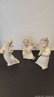 Group shot of three Lladro child musician figurines