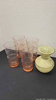 Four pink tumblers and small green vase grouped together