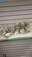 Group shot of the full White Dogwood china assortment on shelf