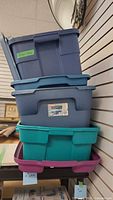 Stack of four plastic storage bins showing colours and lids
