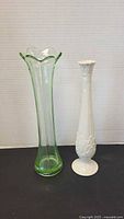 Green glass and white porcelain vases side by side
