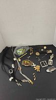 Overview of all bolo ties, buckles, cufflinks, clips and brooch on black background
