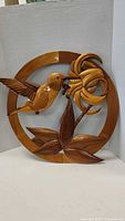 Full view of circular wood plaque with hummingbird and flower