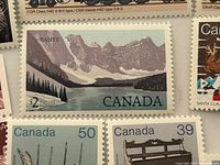 Close-up of Banff 2¢, 50¢ canoe, 39¢ sleigh, 15¢ trillium and other Canadian stamps