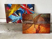 Both abstract canvas prints standing side by side, showing full artwork and condition