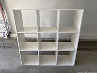 Front view showing 3x3 cubby layout and white laminate finish