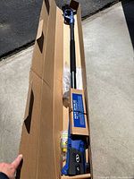 Pole chainsaw inside original box with shaft, oil bottle and packing visible