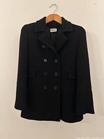 Front view of black wool double-breasted jacket on hanger
