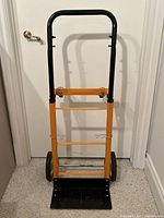 Front view of orange and black metal hand truck dolly