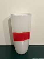 Full view of white glass vase with red band