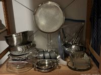 Overall view of stainless bowls, tart pans, springforms, utensil bags, glassware