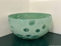 Front view of green art glass bowl showing circular inclusions