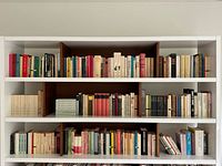 Full bookshelf showing multiple rows of vintage paperbacks and a few hardcovers