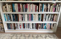 Two full shelves of assorted hardcover and paperback non-fiction books