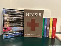 All DVD sets and individual DVDs standing and stacked on table