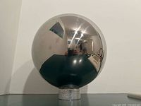 Front view of chrome mirrored gazing ball on base