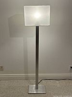 Full view of brushed metal floor lamp illuminated