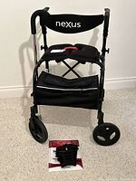 Front view of Nexus rollator walker with seat and pouch, foot brace package on floor