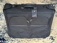 Front view showing dual zip pockets and luggage tag