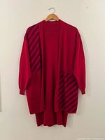 Full view of dress and cardigan hanging front