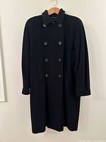 Front view of black double-breasted full-length coat