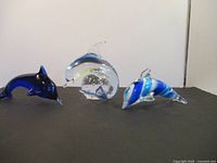 All three glass dolphin figurines on display