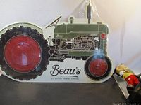 Full view of tractor-shaped Beau's metal sign