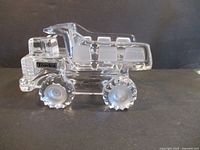 Left side view of clear crystal Tonka dump truck paperweight showing logo decal and frosted wheel centers