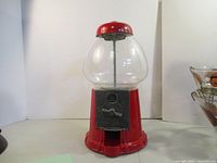 Front view of red gumball machine showing knob and coin mechanism