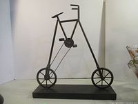 Full view of metal bicycle sculpture on base