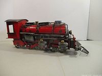 Right side view of entire red metal locomotive