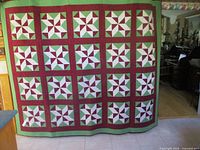 Full view of the quilt hung vertically showing size and 20 star blocks
