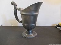Front view of pewter jug on pedestal base