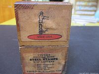 Paper-labeled end of wooden box showing Young's Machine Made Steel Stamps 3/16" Letters text