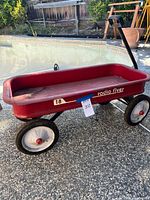Left side view of red Radio Flyer #18 wagon next to pool