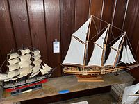 Both model ships on shelf showing overall condition and size