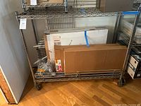 Full view of chrome rack with boxes and parts on lower shelf