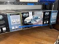 Three Hunter ceiling fan boxes on shelf