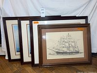 Four framed maritime artworks standing together
