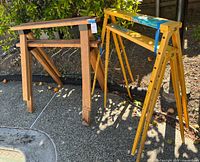 Group shot of two wooden and two yellow metal sawhorses outdoors