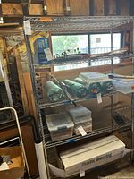 Full view of chrome wire rack with five shelves on casters