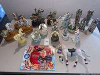 Group shot of carousel horses, unicorns, snow globes, village buildings, show horse and circus program