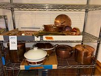 Shelved assortment of copper pots, bowl, canister, utensils box, ceramic casserole