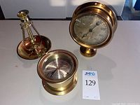 All three brass nautical items on table