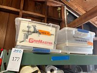 Plastic totes labeled GripMaster Clamp System and Tru-Grip Woodworking Clamps & Guides on shelf